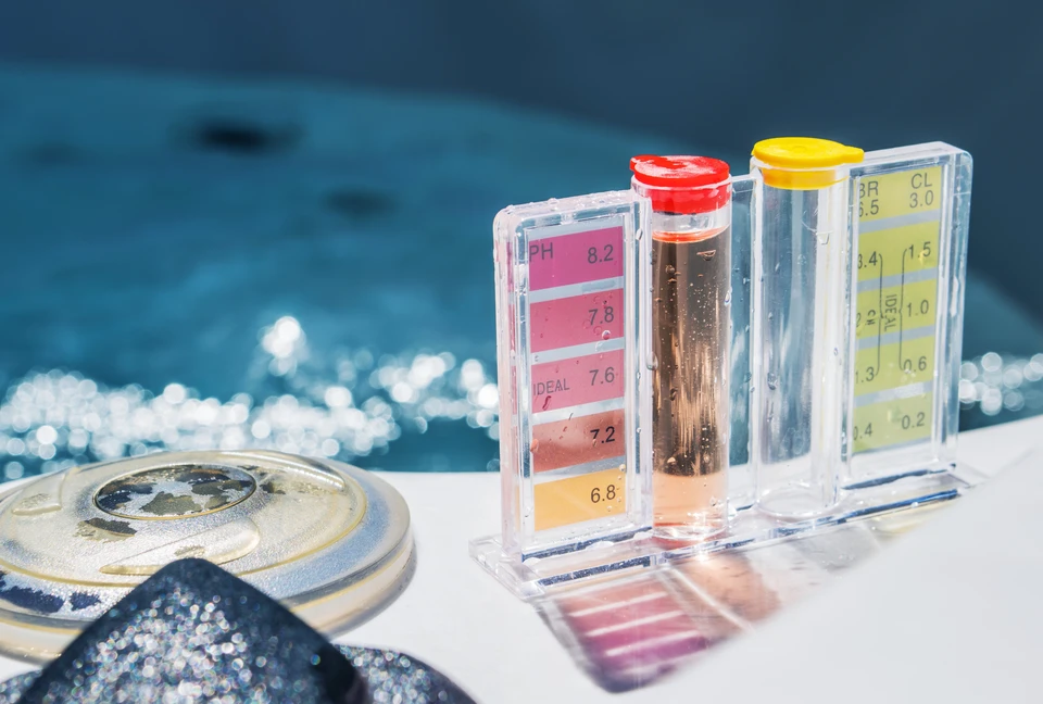 Scène extérieure au bord d'une piscine avec équipements d'analyse chimique de l'eau disposés sur margelle blanche