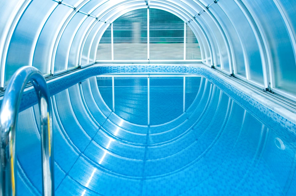 Extérieur résidentiel avec piscine couverte par un abri télescopique transparent semi-cylindrique