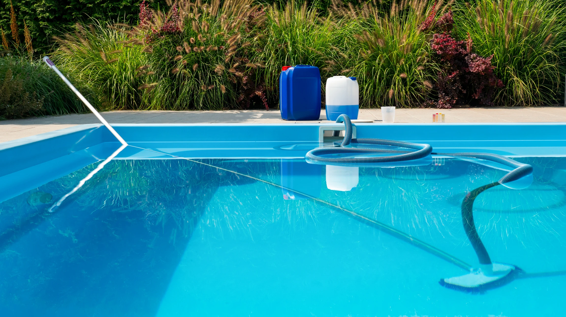 Gros plan d'une piscine privée récemment restaurée avec un liner bleu clair ou gris moderne neuf, montrant l'eau limpide et cristalline dans une piscine circulaire ou rectangulaire classique, avec le rebord de margelle et quelques éléments de l'équipement de la piscine visibles (skimmer, escaliers), sous un ciel ensoleillé provençal. L'image doit capter la qualité premium et la fraîcheur de l'eau après un remplacement de liner professionnel.